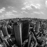 Vista aérea em preto e branco do horizonte urbano de São Paulo, com edifícios densamente concentrados.