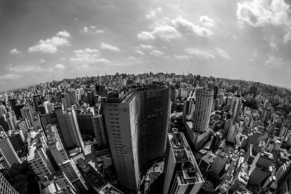 Vista aérea em preto e branco do horizonte urbano de São Paulo, com edifícios densamente concentrados.