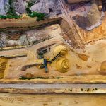 Vista aérea de uma pedreira com máquinas extraindo e processando materiais minerais.