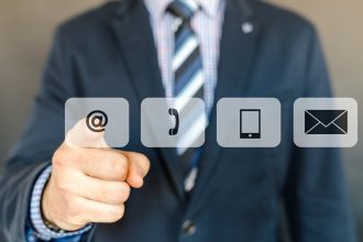 Imagem conceitual de uma pessoa tocando ícones de telefone, e-mail e contato em uma interface digital azul.