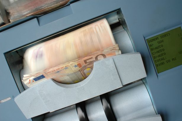 Cédulas de 50 euros sendo processadas em uma máquina contadora de dinheiro.